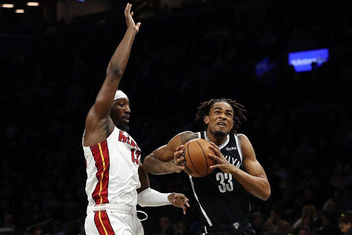 NEW YORK, NEW YORK - DECEMBER 18: Nic Claxton #33 of the Brooklyn Nets goes to the basket as Bam Adebayo #13 of the Miami Heat defends during the first half at Barclays Center on December 18, 2025 in the Brooklyn borough of New York City. NOTE TO USER: User expressly acknowledges and agrees that, by downloading and or using this photograph, User is consenting to the terms and conditions of the Getty Images License Agreement. (Photo by Sarah Stier/Getty Images)