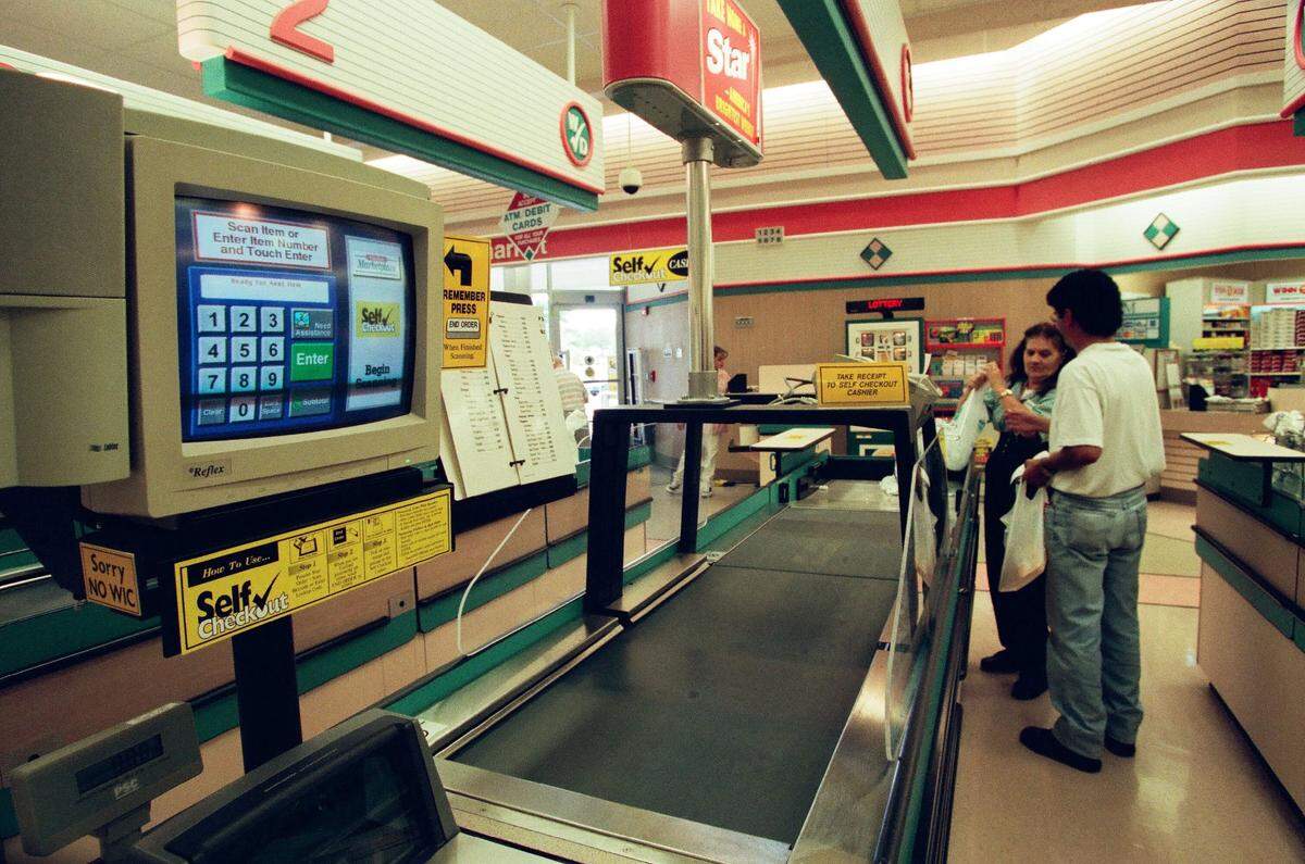 Customers use a new self-checkout lane at a Winn-Dixie store in 1999.