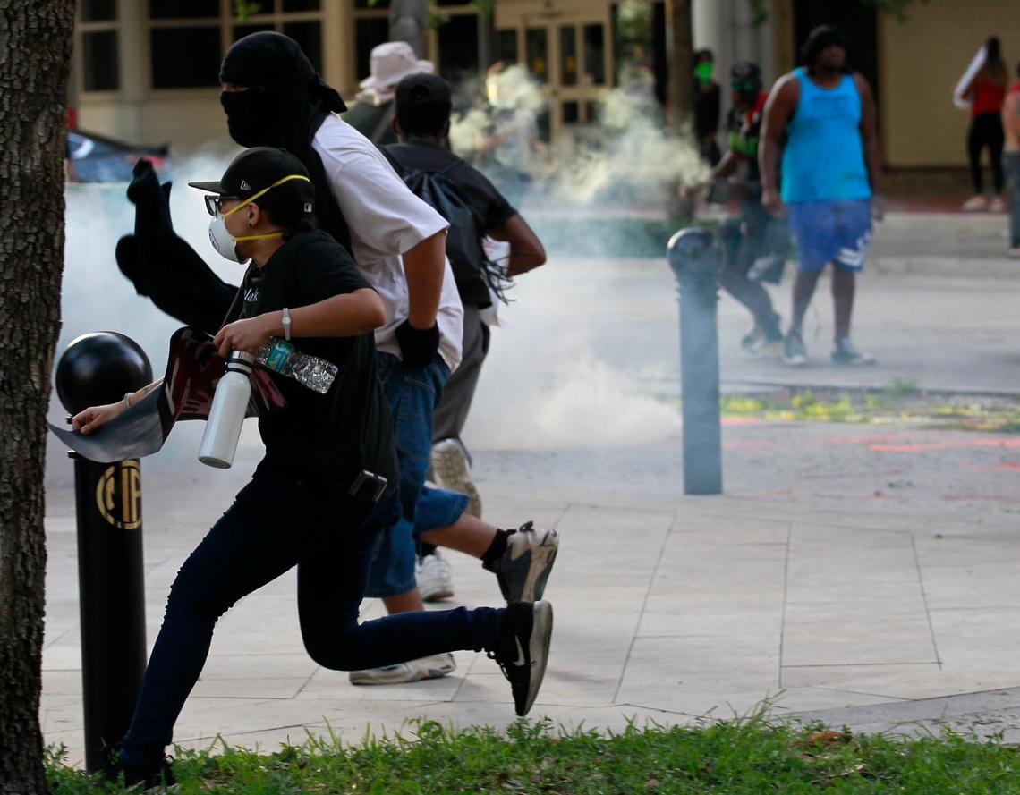 Protesters run as Fort Lauderdale police fire tear gas in downtown Fort Lauderdale on Sunday, May 31, 2020. BSO was called in for backup.