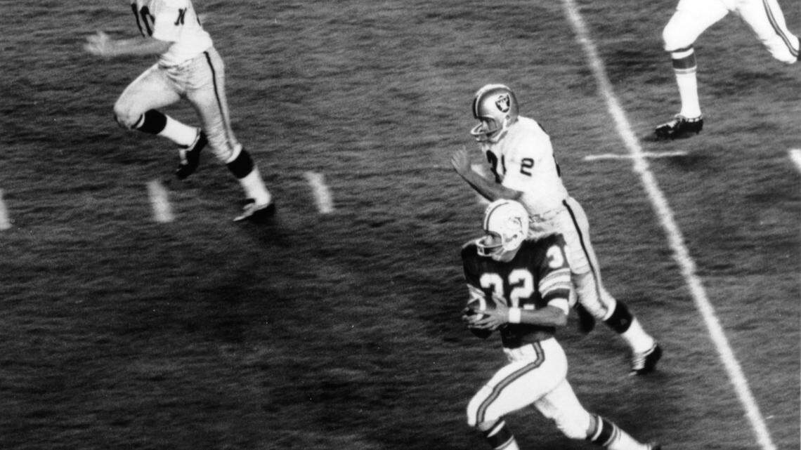 In this Sept. 2, 1966 file photo, Joe Auer of the Miami Dophins takes the kickoff in the first play of the Dolphins first-ever game and runs 95 yards for a touchdown before 26,776 fans at the Miami Orange Bowl. Auer is pursued by Oakland’s Mike Mercer (10) and Rodger Bird (21). Auer played football at Coral Gables High. Oakland won the game, 23-14.
