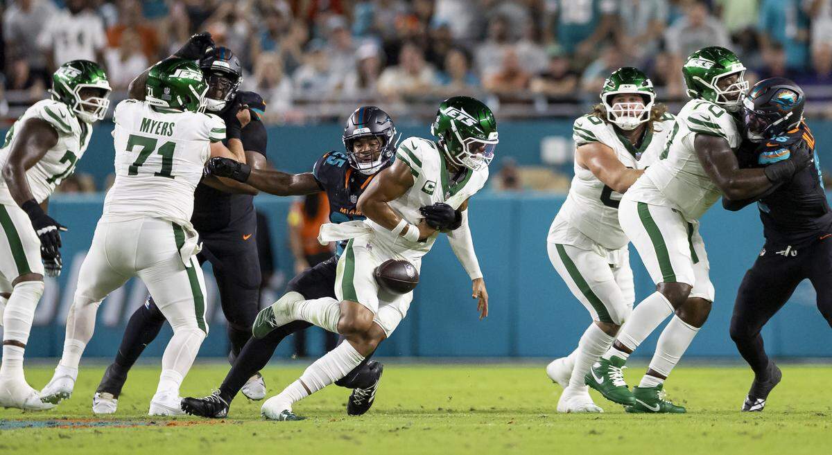 Miami Dolphins linebacker Tyrel Dodson (25) causes New York Jets quarterback Justin Fields (7) to fumble in the first half of their NFL game at Hard Rock Stadium on Monday, Sept. 29, 2025, in Miami Gardens, Fla.
