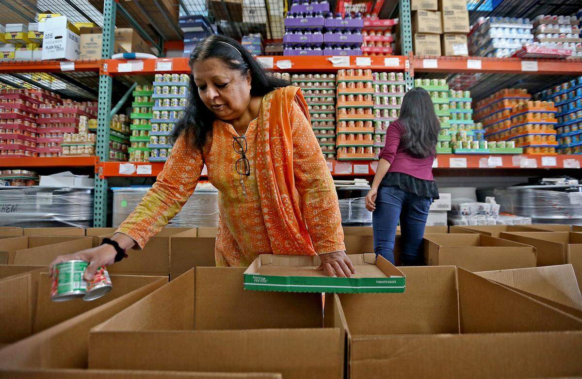 In this file photo, Kausar Haroon loads a box with food at the Islamic Foundation of South Florida on May 21, 2017. Haroon and her team give out food boxes from the pantry full of all the staples to about 170 needy families a month. The IFSF and Islamic School of Miami will also offer free food during the January 2019 government shutdown.