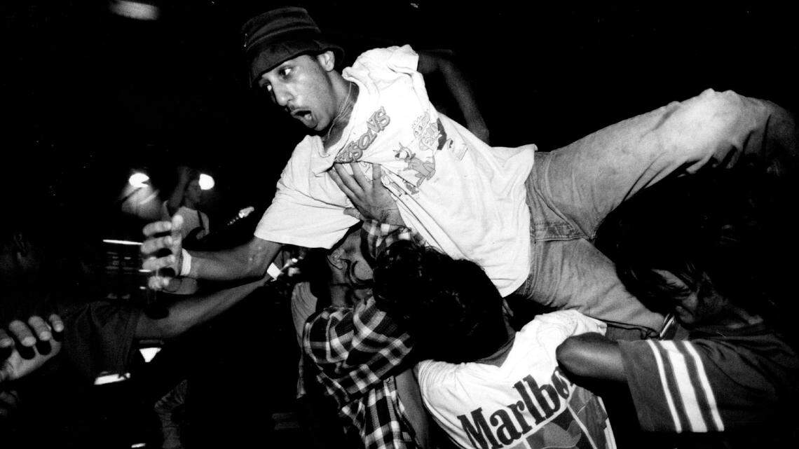 A clubgoer is carried through and over the crowd after jumping head first off of the stage during a show at Washington Square on South Beach in 1993.