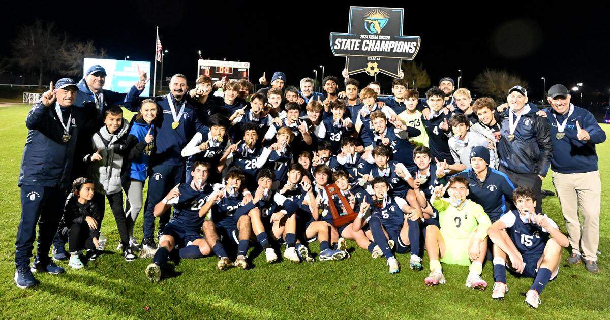 Gulliver Prep players and coaches gather together with the state championship trophy after winning the Class 4A boys soccer state championship on Saturday at Lake Myrtle Park in Auburndale.