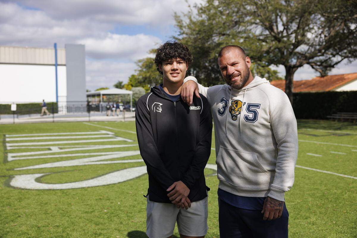 Dominic Turnbull, Florida International University recruit, left, poses with his father and coach, Nick Turnbull, former NFL player and FIU alum, after Signing Day for True North football players on Wednesday, Dec. 3, 2025, at True North Classical Academy in Miami, Fla. “I got to train him all the way through his career,” said Nick Turnbull.