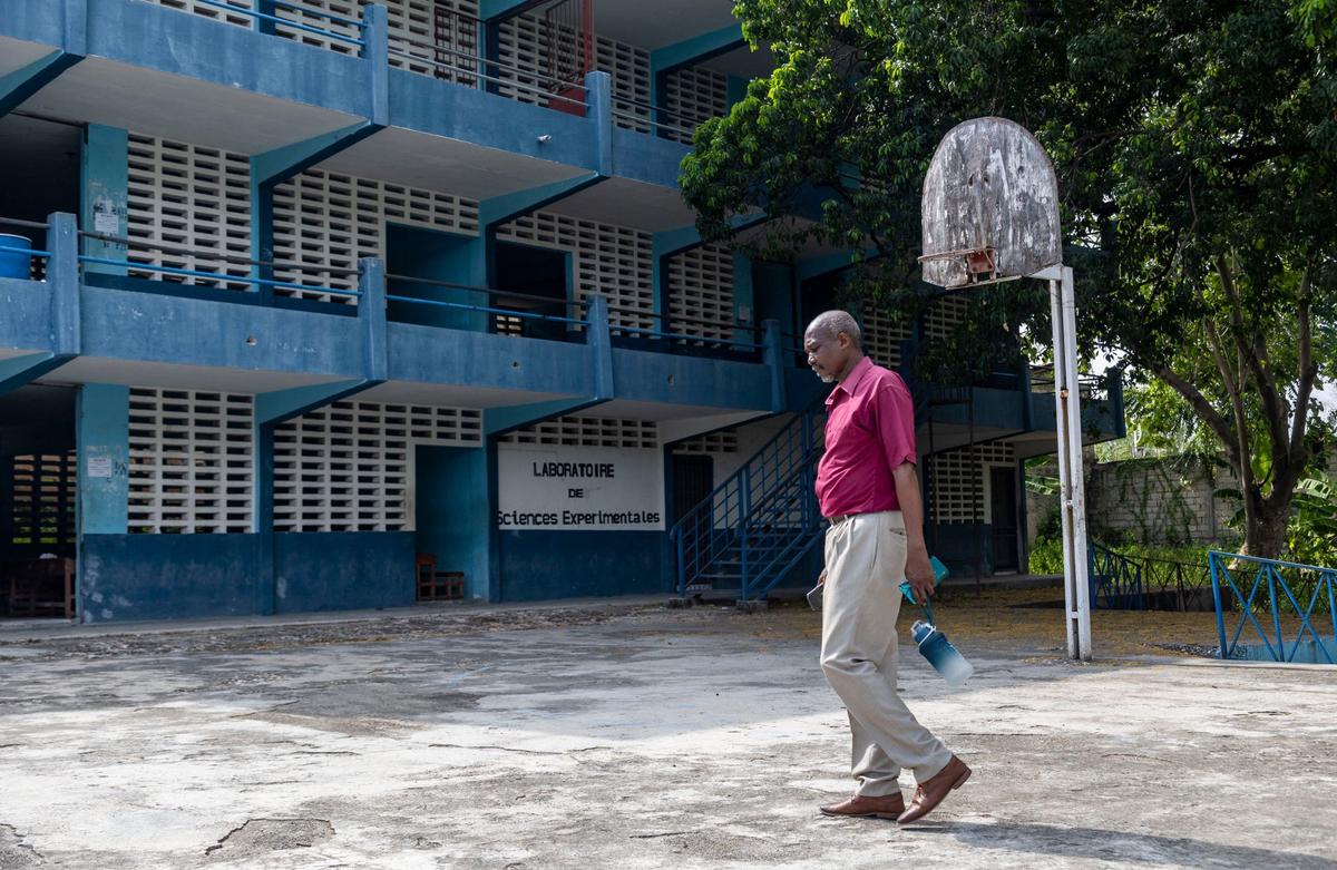 Roc Auxène, a history teacher and regional director for the Ministry of Education for the southeast region of Haiti, walks across the yard at Lycée Pinchinat of Jacmel on August 24, 2024. The school is among several UNICEF, the United Nations’ child welfare agency, is trying to repair to accommodate thousands displaced students fleeing gang violence.