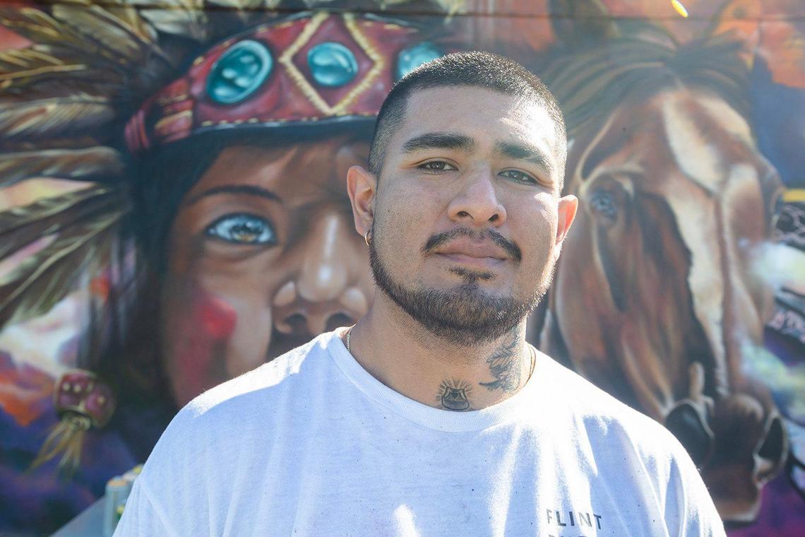 Artist Oliver Crisostomo, known as “Congo,” from Lima, Peru, poses in front of his mural at Madison Middle School.