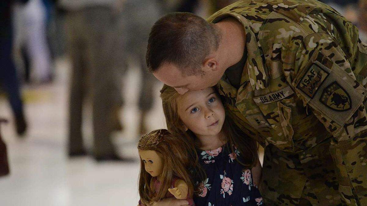 Daniel Millington of Company G, 2nd Battalion, 135th Aviation Regiment shares a quiet moment with his daughter Samantha, 5, as he returns from Afghanistan after 10-month deployment in 2014. 