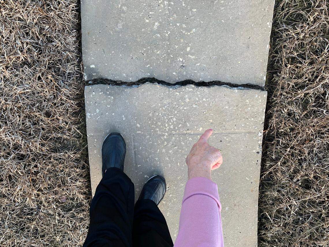 Daryle Prager, 81, points to the cracked concrete in her backyard sidewalk broken by this year’s King Tides. She said she doesn’t have much time before the rising water reaches her waterfront home in Surfside, so she’s forced to sell the house.