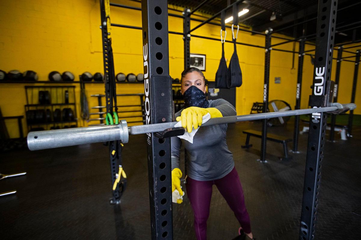 Head coach Milena Maestre sanitizes surfaces at CrossFit Increase at Bruce Zone in Fort Lauderdale.