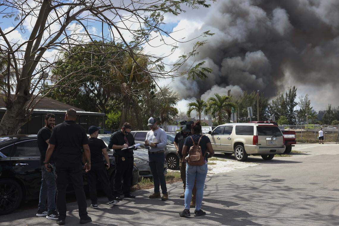 Detectives talk to people who were around the area during a warehouse fire on Thursday, March 5, 2026, in Miami Gardens, Fla.