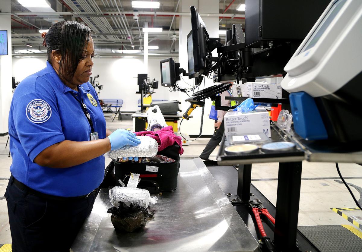 Shonte Hardwick, agente de la TSAm revisa una maleta encima de una mesa robotizada, parte de un sistema avanzado de equipaje en el Aeropuerto Internacional de Miami, en una imagen del 10 de octubre de 2019.