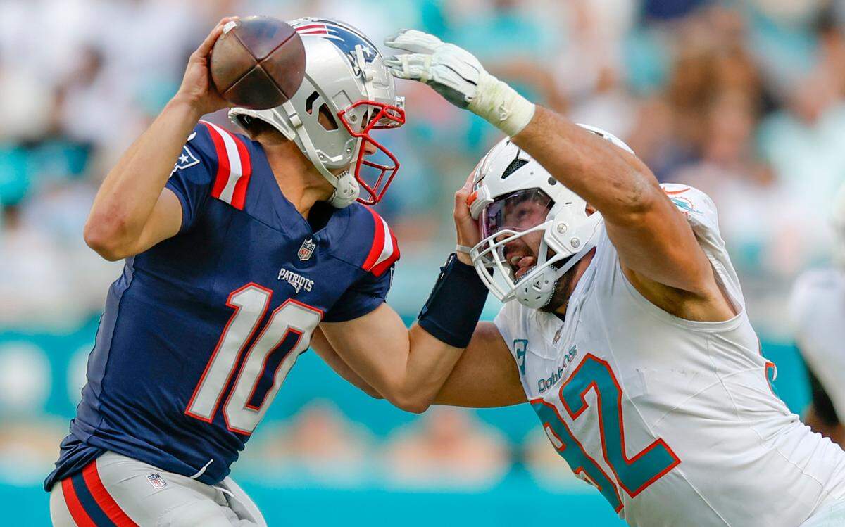 Miami Dolphins defensive tackle Zach Sieler (92) pressures New England Patriots quarterback Drake Maye (10) just before knocking the ball out of his hands for a fumble recovered by Dolphins linebacker Jordyn Brooks (20) in the second half of their NFL football game at Hard Rock Stadium in Miami Gardens, Florida, on Sunday, November 24, 2024.