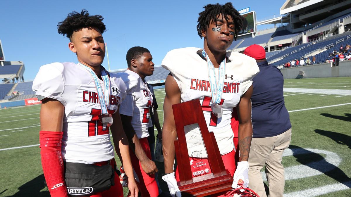 Champagnat Lions’s Lamar Spencer (10) and Johnquai Lewis (4) hold the runner uo trophy after losing to North Florida Christian Eagles in the Florida High School Athletic Association State Chapionships Class 2A at Camping World Stadium in Orlando on Friday, December 7, 2018.