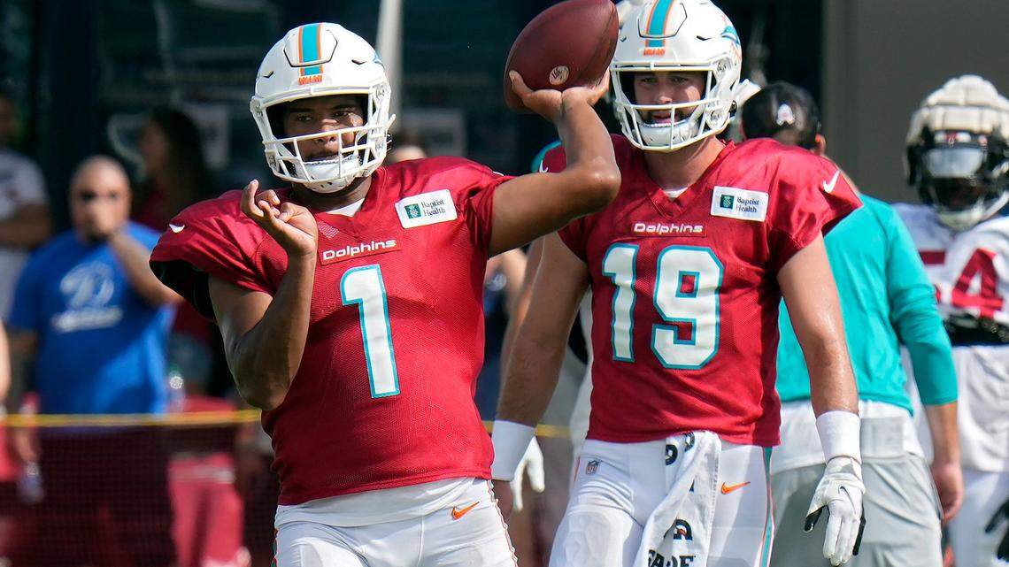 Miami Dolphins quarterback Tua Tagovailoa (1) throws a pass during an NFL football training camp practice with the Tampa Bay Buccaneers Wednesday, Aug. 10, 2022, in Tampa, Fla. Looking on is quarterback Skylar Thompson (19). (AP Photo/Chris O’Meara)