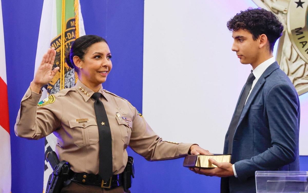 During a swearing-in ceremony, Miami-Dade County Sheriff Rosie Cordero-Stutz takes the oath of office with her left hand on a Bible at Miami-Dade College School of Justice in Miami on Tuesday, Jan. 7, 2025. Her son Evan holds the Bible.