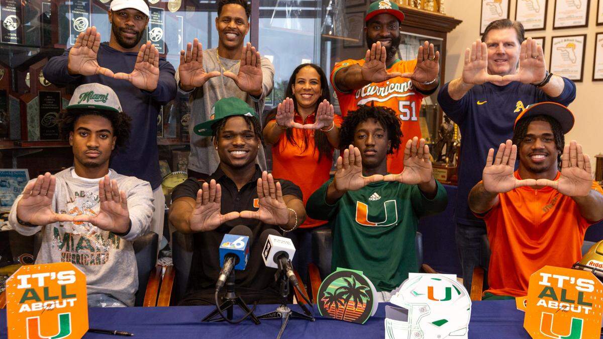 St. Thomas Aquinas football players and UM signees, from left to right, Ryan Mack, Chance J Robinson, Romanas Frederique and Jordan Lyle throw up the ‘U’ during signing day at St.Thomas Aquinas High School in Fort Lauderdale, Florida, on Wednesday, December 20, 2023.