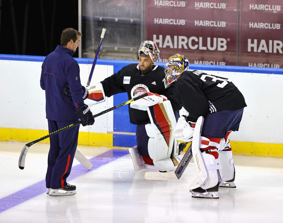 Florida Panthers goaltending coach Robb Tallas talks with Panthers goaltenders Spencer Knight (30) and Christopher Gibson (31) during training camp in preparation for the 2021-22 NHL season at the FLA Live Arena on Thursday, September 23, 2021 in Sunrise, Florida.