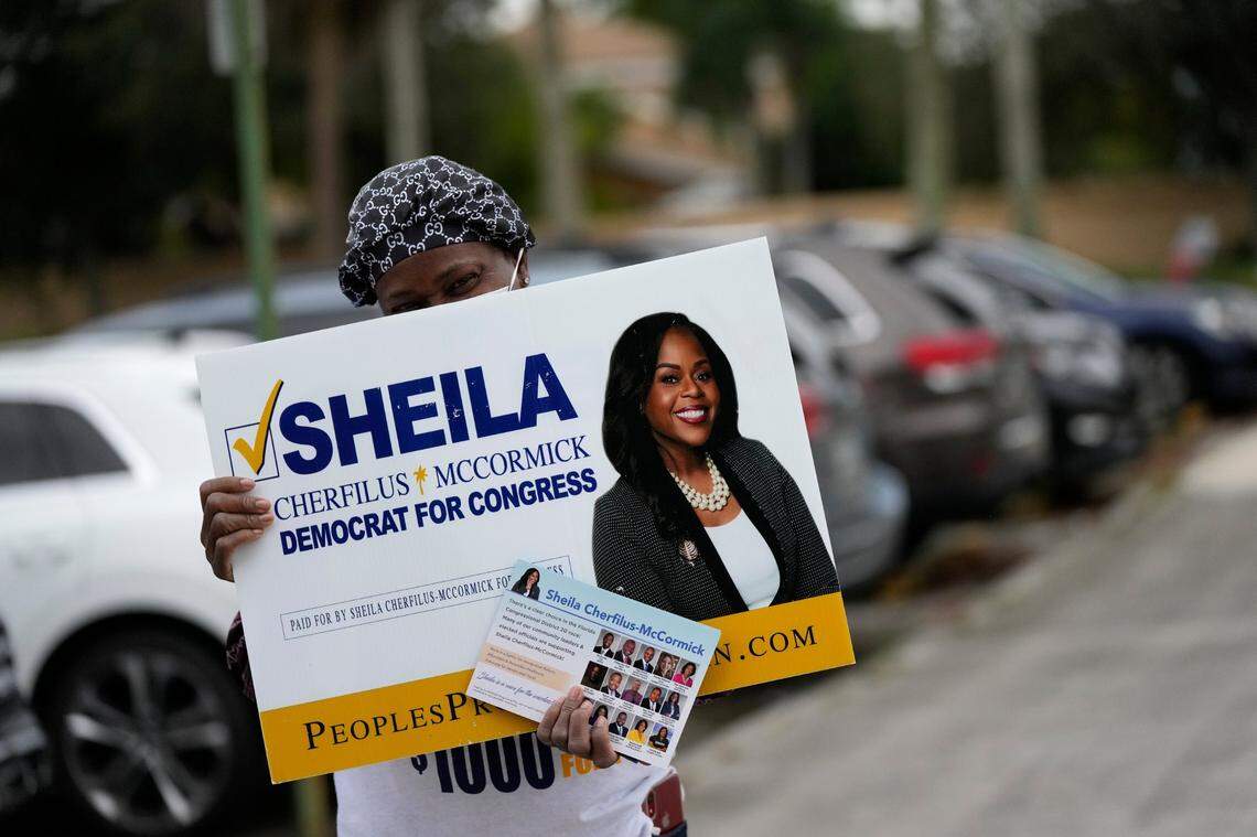A woman campaigns outside a polling place for Sheila Cherfilus-McCormick, a candidate in the Democratic primary race for Florida’s 20th Congressional District seat, in Miramar on Election Day, Tuesday, Nov. 2, 2021.