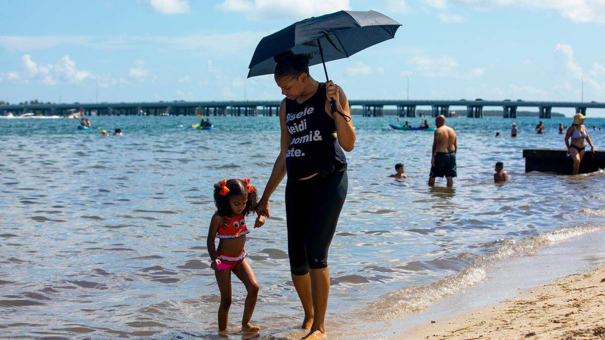 Chimene Purdy, 36, walks with her daughter Naomi Jackson, 5, on the beach during the rescheduled Historic Virginia Key Beach Park Day 75th Anniversary Celebration at Virginia Key Beach Park in Miami-Dade on Saturday, Aug. 8, 2020.