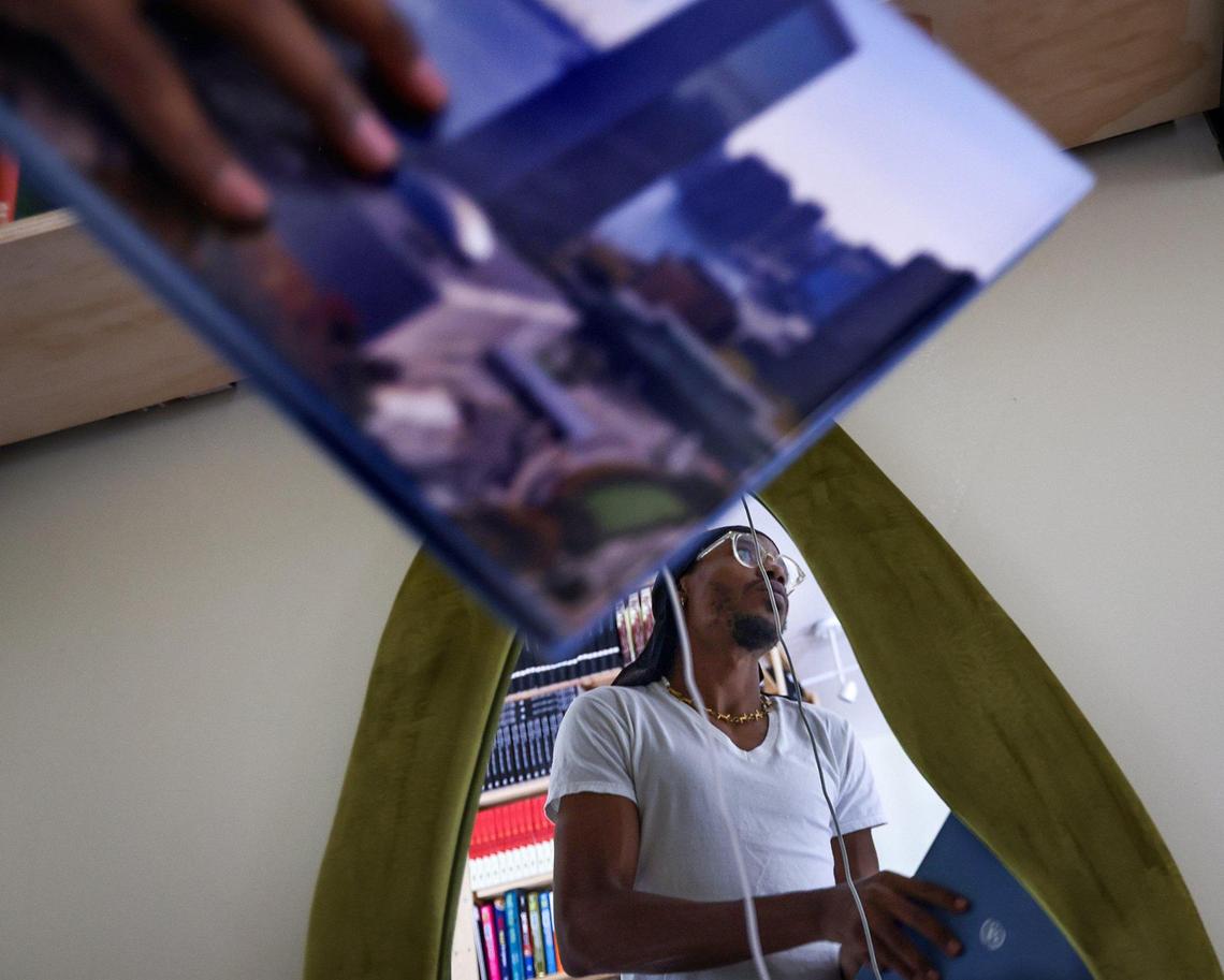 Cameron Agnew, 31, left, shelves donated books at the Roots Bookstore on Tuesday, June 17, 2025, in Miami, Florida. Roots Bookstore and Marketplace, the brainchild of the late Danny Agnew, is set to open on Juneteenth, thanks to the hard work of his brother Phillip Agnew, Sherina Jones, Isaiah Thomas, and a team of volunteers in Miami, Florida, on June 17, 2025.