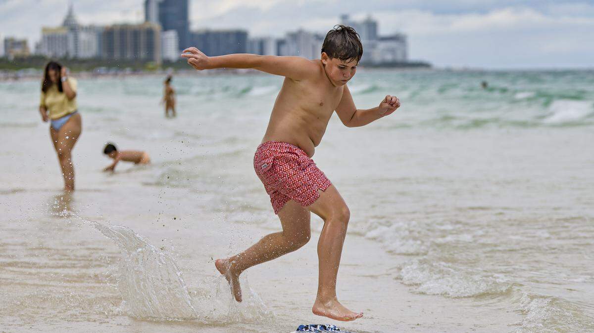 Leopoldo Briceno, 14, skimboards near South Pointe Park on Miami Beach, Florida, on Tuesday, April 7, 2026.