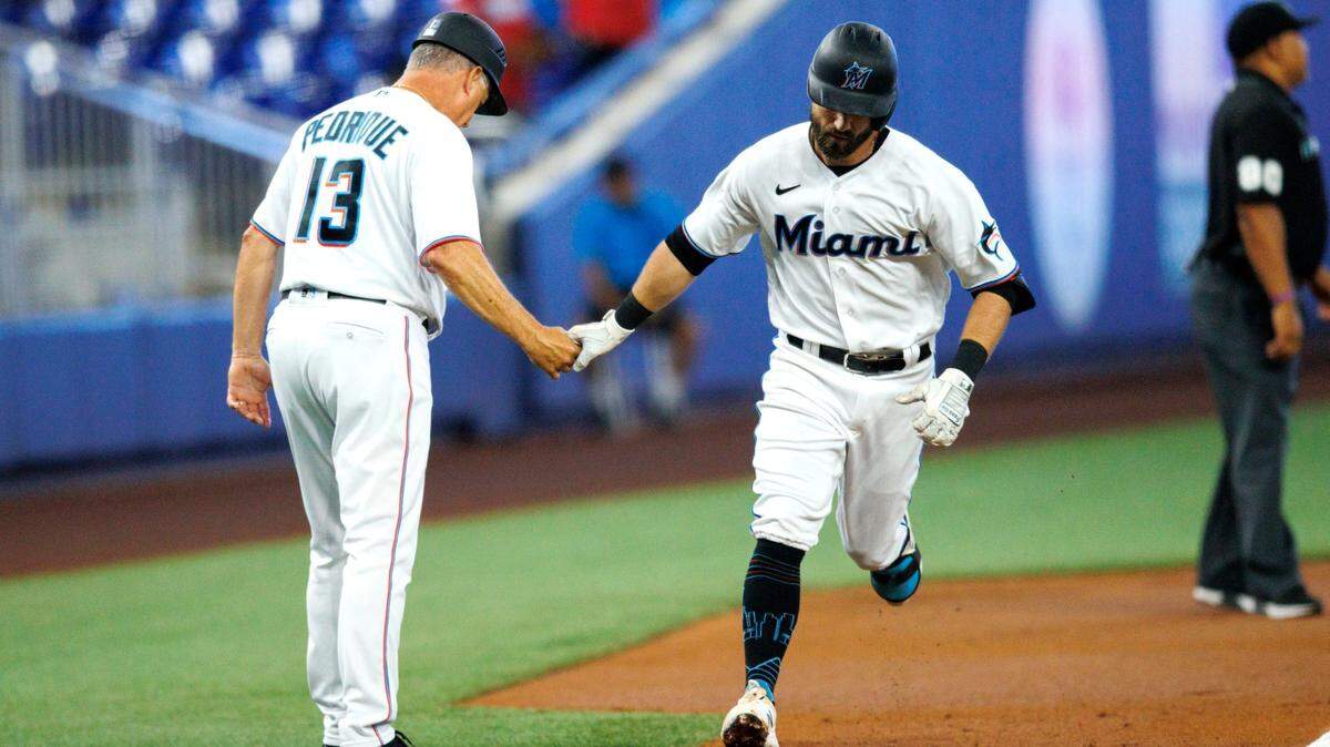Miami Marlins third baseman Jon Berti (5) is congratulated by third base coach Al Pedrique (13) after hitting a solo home run during the first inning of the baseball game against the Arizona Diamondbacks at LoanDepot Park on Wednesday, May 4, 2022 in Miami, Florida.