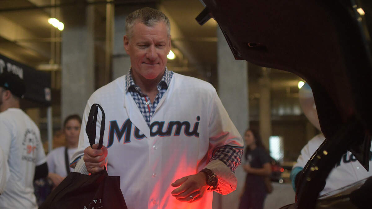 Jeff Conine puts a bag of food into a car during the Miami Marlins’ Thanksgiving food distribution on Friday, Nov. 18, 2022.