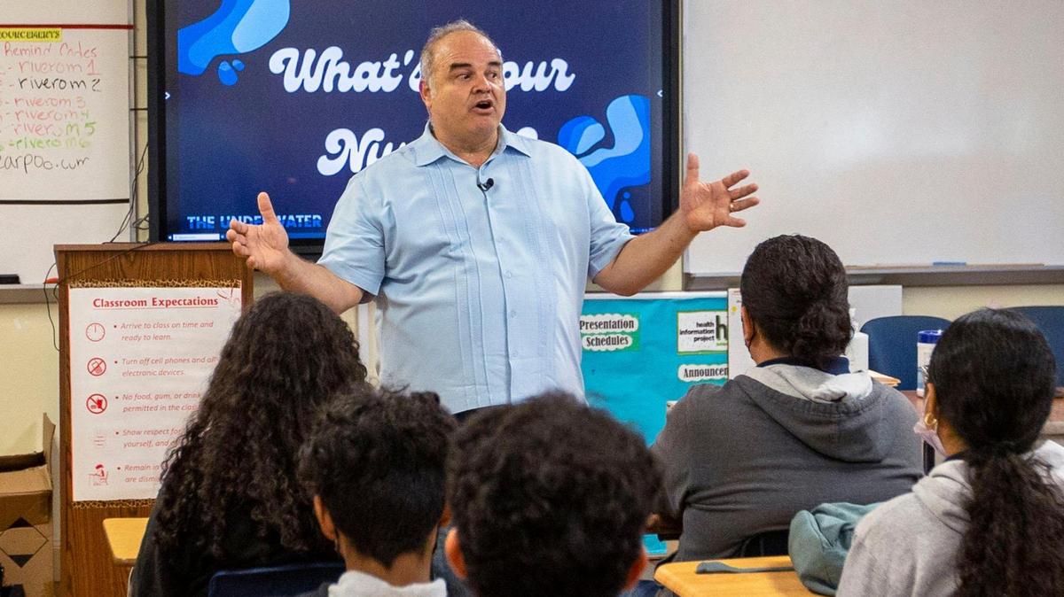 El artista cubano Xavier Cortada habla a una clase de Ciencia ssobre su proyecto ecológico "The Underwate" que enseña a los estudiantes sobre el aumento del nivel del mar.