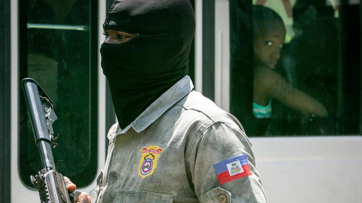 Un agente de la Policía Nacional de Haití observa el tráfico en un puesto de control el 23 de junio de 2022 en Tabarre, donde los recientes brotes de pandillas han sembrado el pánico entre la población. La Policía haitiana afirma que carece del equipo adecuado para combatirlas.