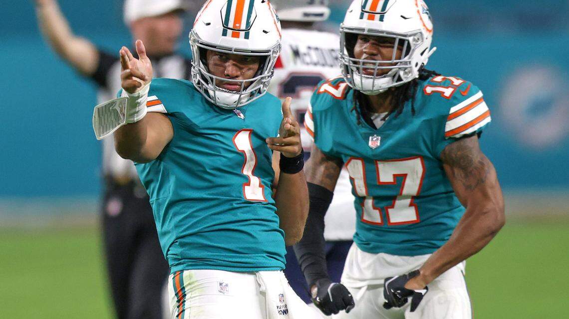 Miami Dolphins quarterback Tua Tagovailoa (1) celebrate with Dolphins wide receiver Jaylen Waddle (17) after running for a first down during the fourth quarter of an NFL football game against the New England Patriots at Hard Rock Stadium on Sunday, January 9, 2022 in Miami Gardens, Florida. (David Santiago Photo / Miami Herald)