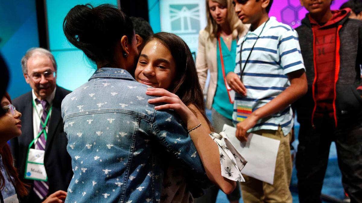Simone Kaplan, 13, a seventh-grader at St. Bonaventure Catholic School in Davie, hugs her mother Alana as she walks offstage after reaching the final round of the Scripps National Spelling Bee, Thursday, May 30, 2019, in Oxon Hill, Maryland