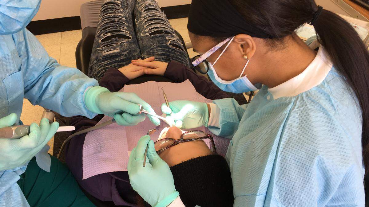 Ratrice Jackson, then a fourth-year student at Meharry Medical College in Nashville, Tennessee, drills out cavities as part of a free oral health day on campus in 2018. (Blake Farmer/Nashville Public Radio) 
