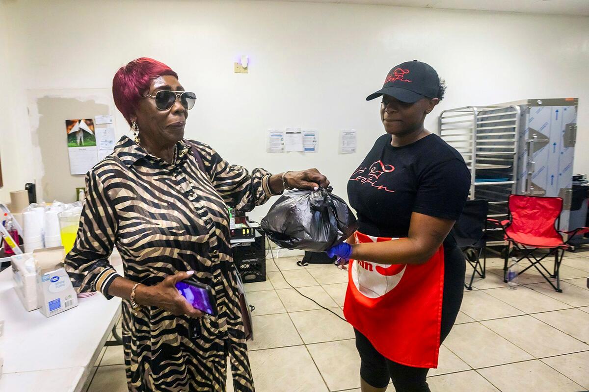 Ruby Jones, 81, receives her meal from Chef Syerra Donaldson during a vending event at EasyCookinWithSy in Miami Gardens on Saturday, May 24, 2025.