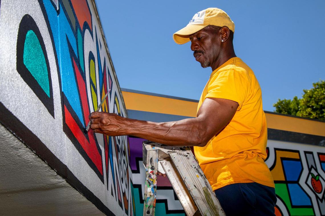 El artista y profesor Darryn Ferguson trabaja en su creación, el mural envolvente más grande del país, en el African Heritage Cultural Arts Center de Liberty City, Florida, el sábado 1º de mayo de 2021.