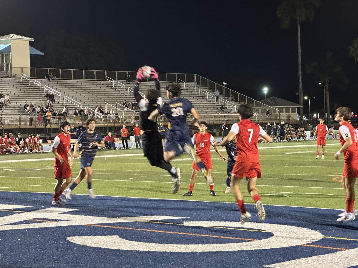 MAST goalkeeper Santiago Varela soars through the air to grab a corner kick by Downtown Doral during their Region 4-3A semifinal on Tuesday night at Tropical Park.