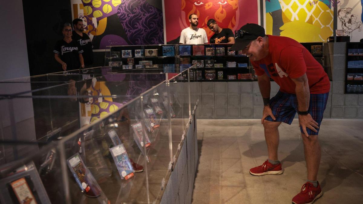 Sigfrido Mucenieks, 50, of Sportcards4u, smiles as he visually samples the items being sold at Loupe, a new sports card shop in Wynwood.