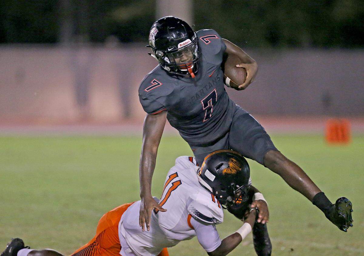 Booker T Washington’s Eddie Jackson (11) tackles Southridge’s Tyrique Stevenson (7) in a Sept. 6 game. Stevenson - being recruited as a cornerback - will announce on Wednesday whether he will attend UM or Georgia.