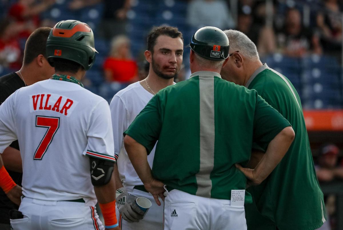 UM freshman CJ Kayfus (center) got hit with a pitch just above the right corner of his mouth against South Alabama in the Gainesville Regional on Friday, June 4, 2021, and UM coach Gino DiMare said he’ll need some stitches but is otherwise fine. 