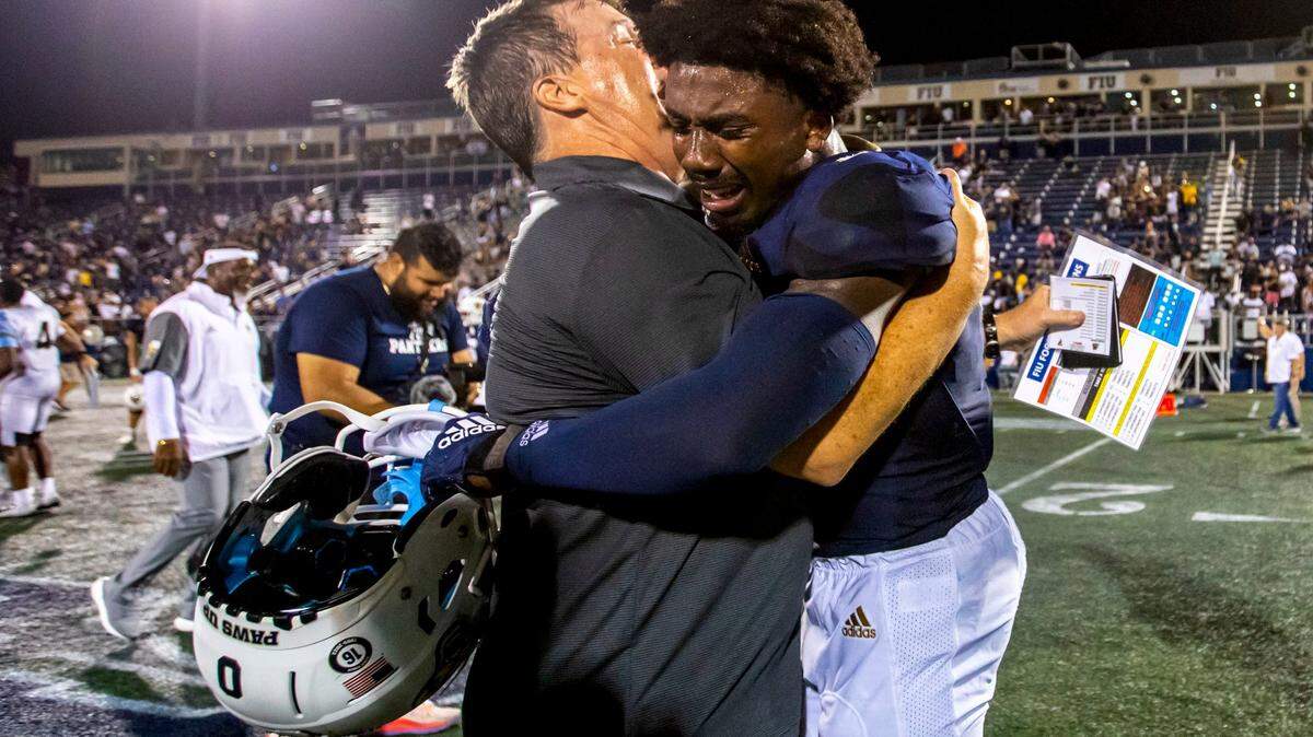 Florida International University Head Coach Mike MacIntyre reacts with wide receiver Tyrese Chambers (0) after defeating Bryant University 38-37 in overtime of an NCAA Conference USA football game at Riccardo Silva Stadium in Miami, Florida, on Thursday, September 1, 2022.