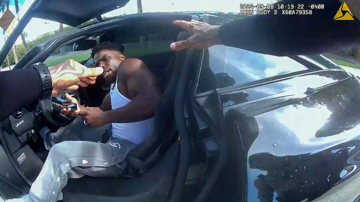 Miami-Dade Police officers approach Miami Dolphins star receiver Tyreek Hill after pulling him over for speeding last Sunday by Hard Rock Stadium. Police body-camera footage shows they yanked him from the car, pinned him to the ground and handcuffed him.