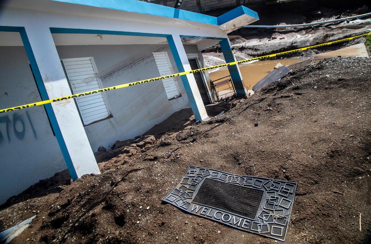 Un tapete de bienvenida frente a la casa de Villa Esperanza que se derrumbó en un socavón durante el huracán Fiona.
