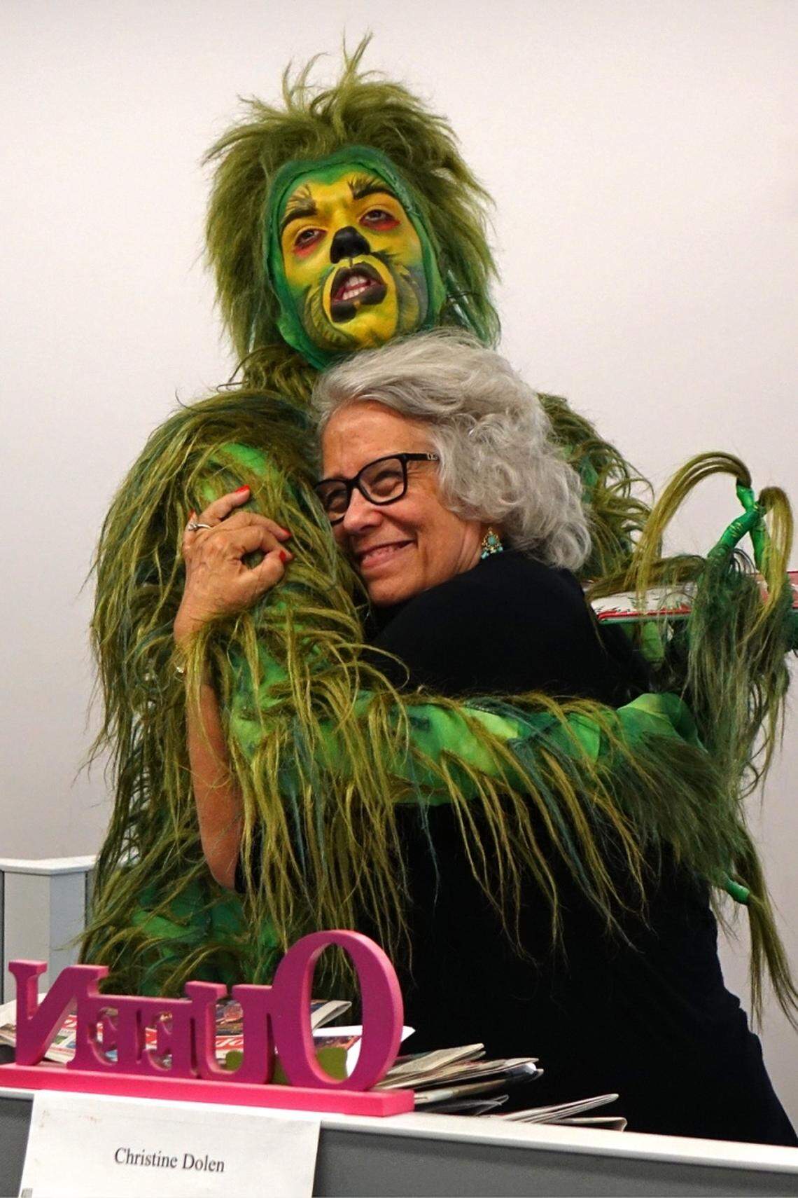 One of pop culture’s famous figures, the Grinch, then starring in a South Florida theater production, surprised the Miami Herald’s former theater critic on her last day in the office in December 2015. She announced her retirement after serving as the paper’s theater critic since 1979 and her friends at Broadway Across America surprised her in the office with a tribute featuring the Dr. Seuss character.