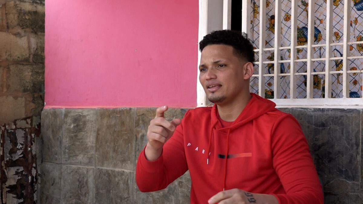 Venezuelan returnee Mervin Yamarte talks to friends inside his house in Los Pescadores in Maracaibo.