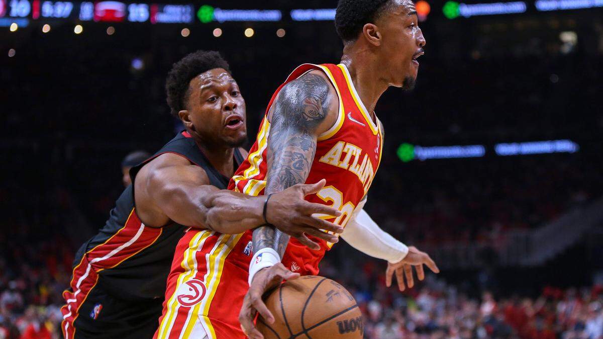Miami Heat guard Kyle Lowry, left, attempts to steal the ball from Atlanta Hawks forward John Collins during the first half of Game 3 of an NBA basketball first-round Eastern Conference playoff series Friday, April 22, 2022, in Atlanta. (AP Photo/Brett Davis)