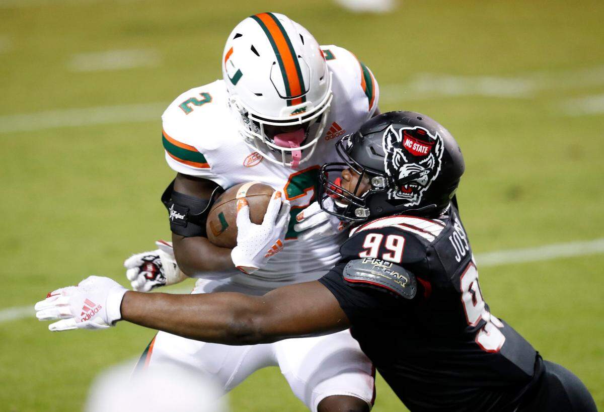 N.C. State defensive lineman Daniel Joseph (99) tackles Miami running back Donald Chaney Jr. (2) during the first half of N.C. States game against Miami at Carter-Finley Stadium in Raleigh, N.C., Friday, Nov. 6, 2020.