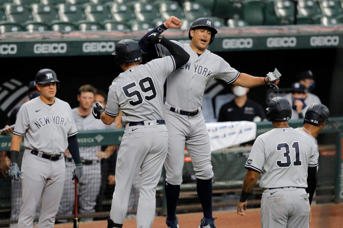 New York Yankees’ Luke Voit (59) celebrates with Giancarlo Stanton, center right, after hitting a grand slam off Baltimore Orioles starting pitcher John Means during the first inning of a baseball game, Thursday, July 30, 2020, in Baltimore. Yankees’ Gleyber Torres, Aaron Hicks (31) and Stanton scored on the grand slam. (AP Photo/Julio Cortez)