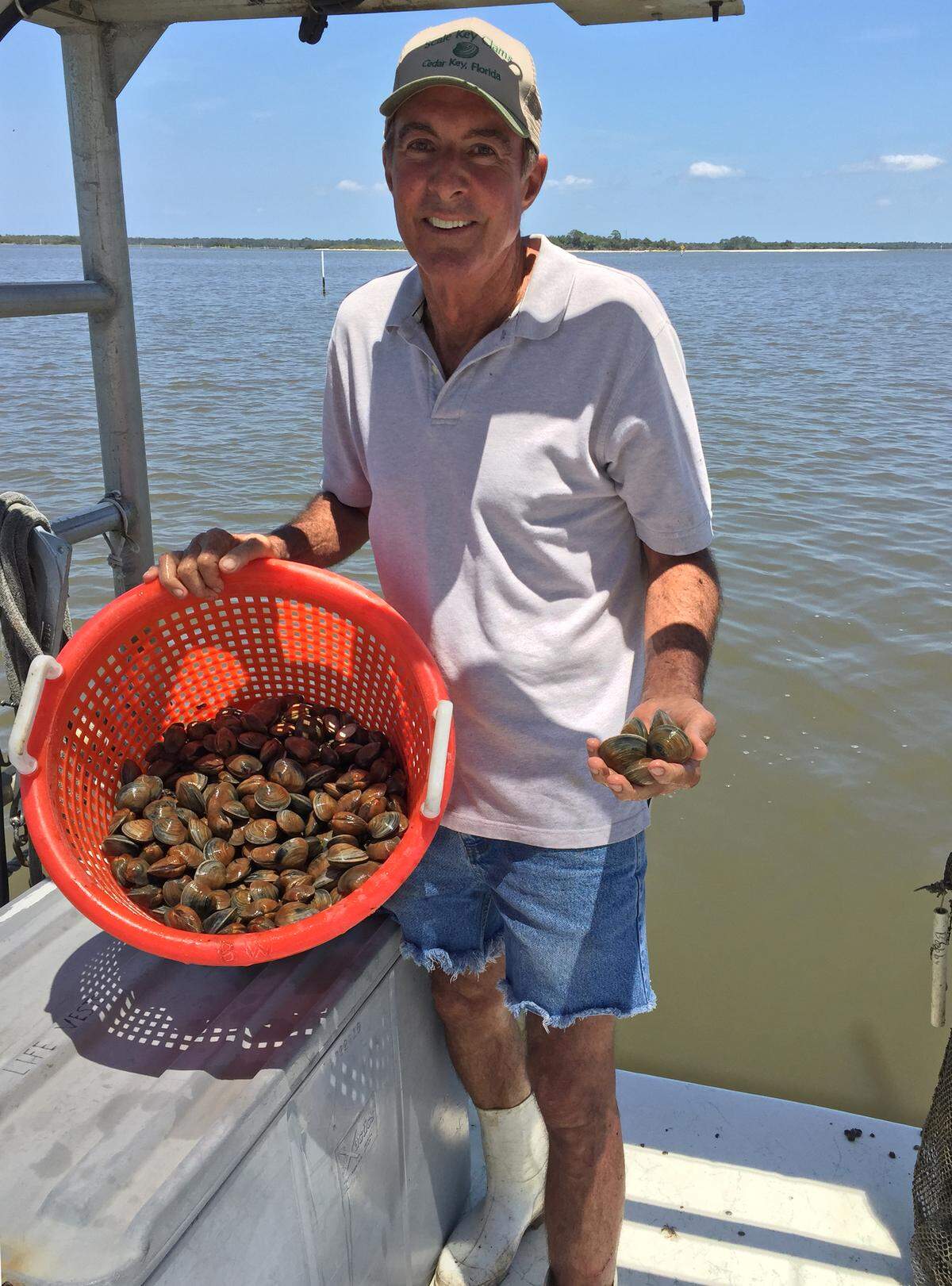 Capt. Bobby holds a bushel of clams farmed off Cedar Key.