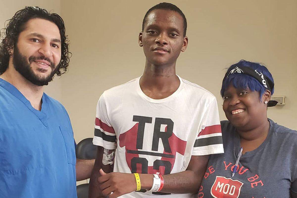 Zohny Zohny (left), a neurosurgeon, stands with his patient Larry Black Jr. and Black’s sister Molly Watts in a photograph taken at a follow-up medical appointment in 2019. Black was shot in the head in St. Louis earlier that year.
