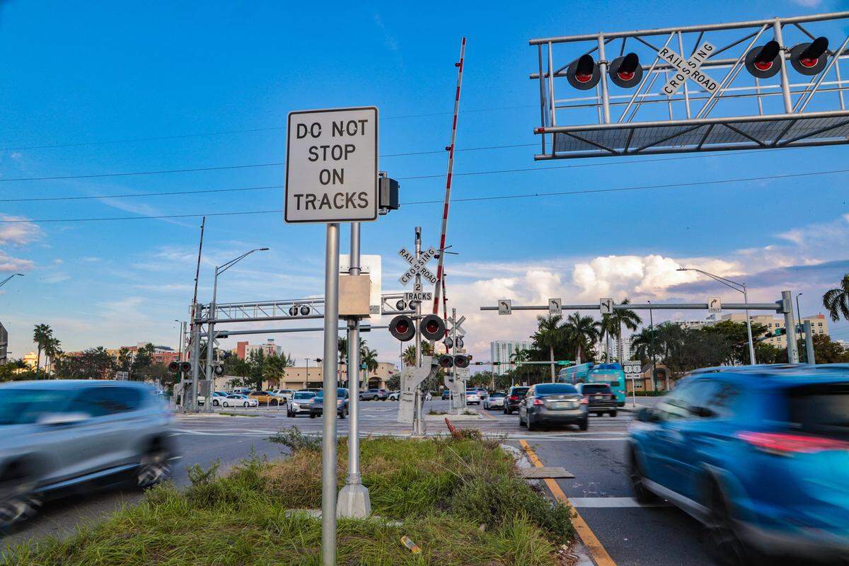 Signs warn drivers not to stop on the tracks at intersections along the Brightline train corridor in Miami.
